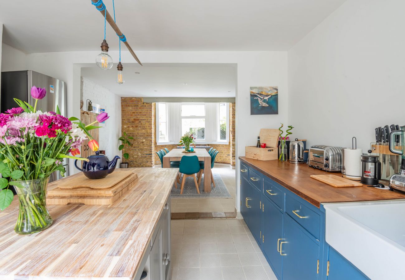 The townhouse kitchen with blue cabinetry and warm timber worktops