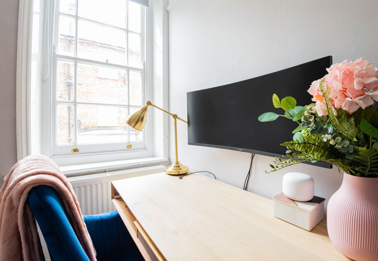Study desk with widescreen monitor beside the window